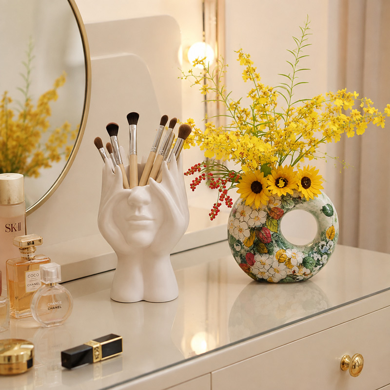 Woman Face Vase for Makeup Brushes with a Donut Vase on a Vanity